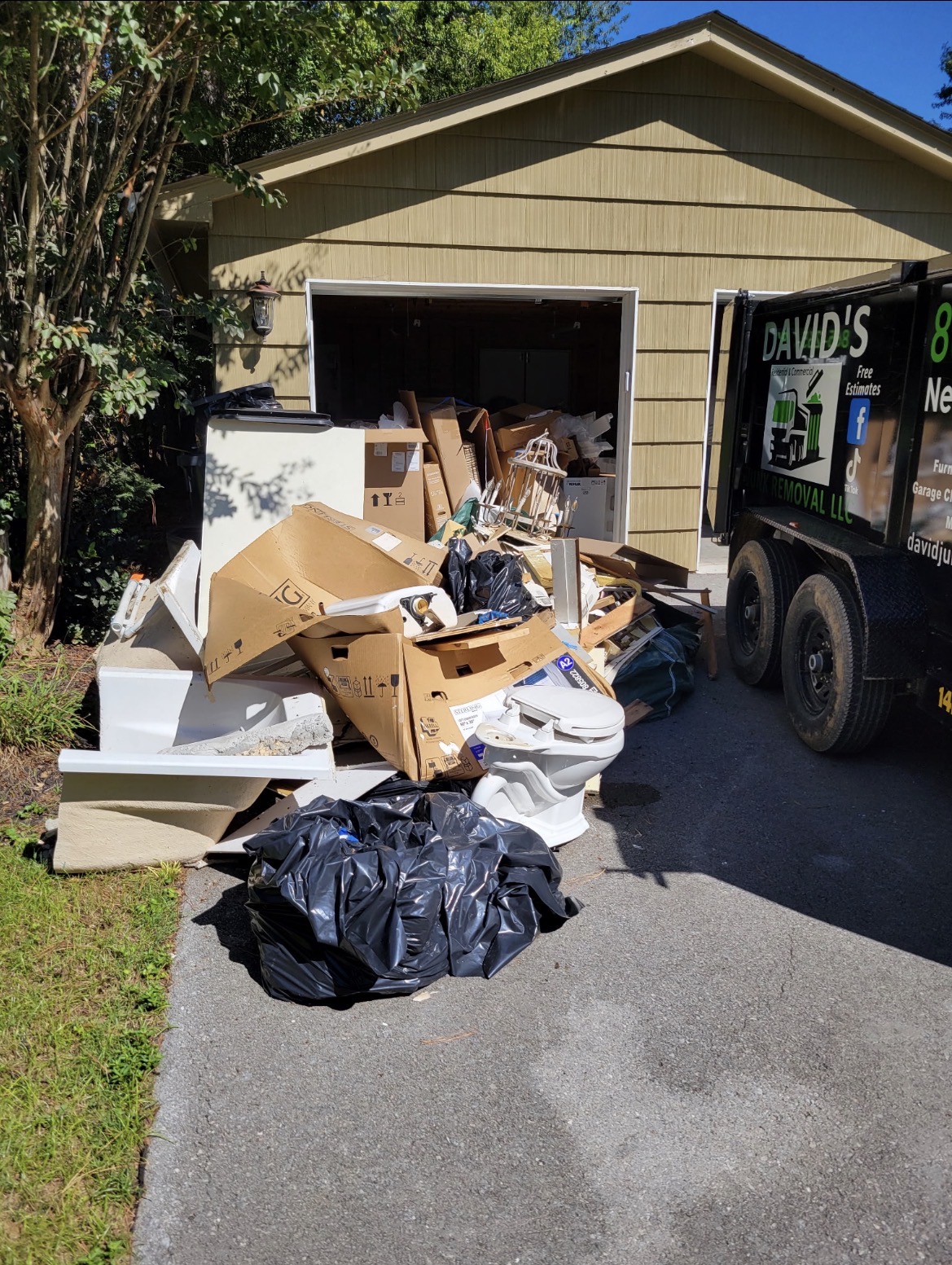 Garage cleanout debris beside David’s Junk Removal trailer