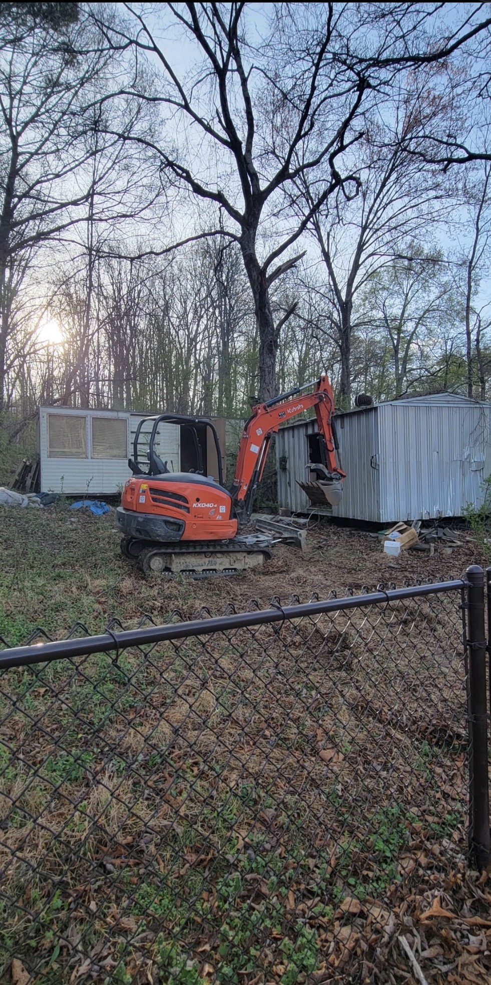 Excavator removing an old structure during a Knoxville property cleanout